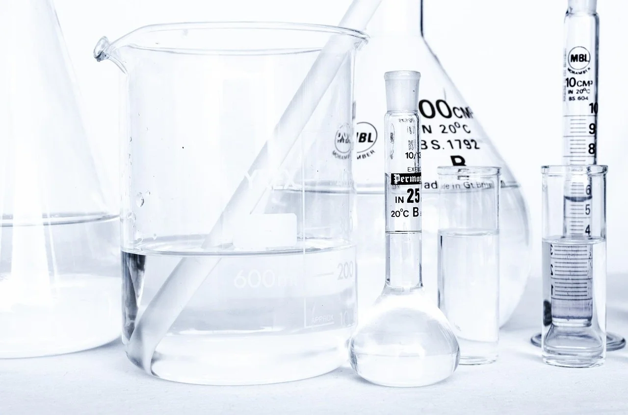 Probetas graduadas y vasos de precipitado de vidrio con agua para medir volumen