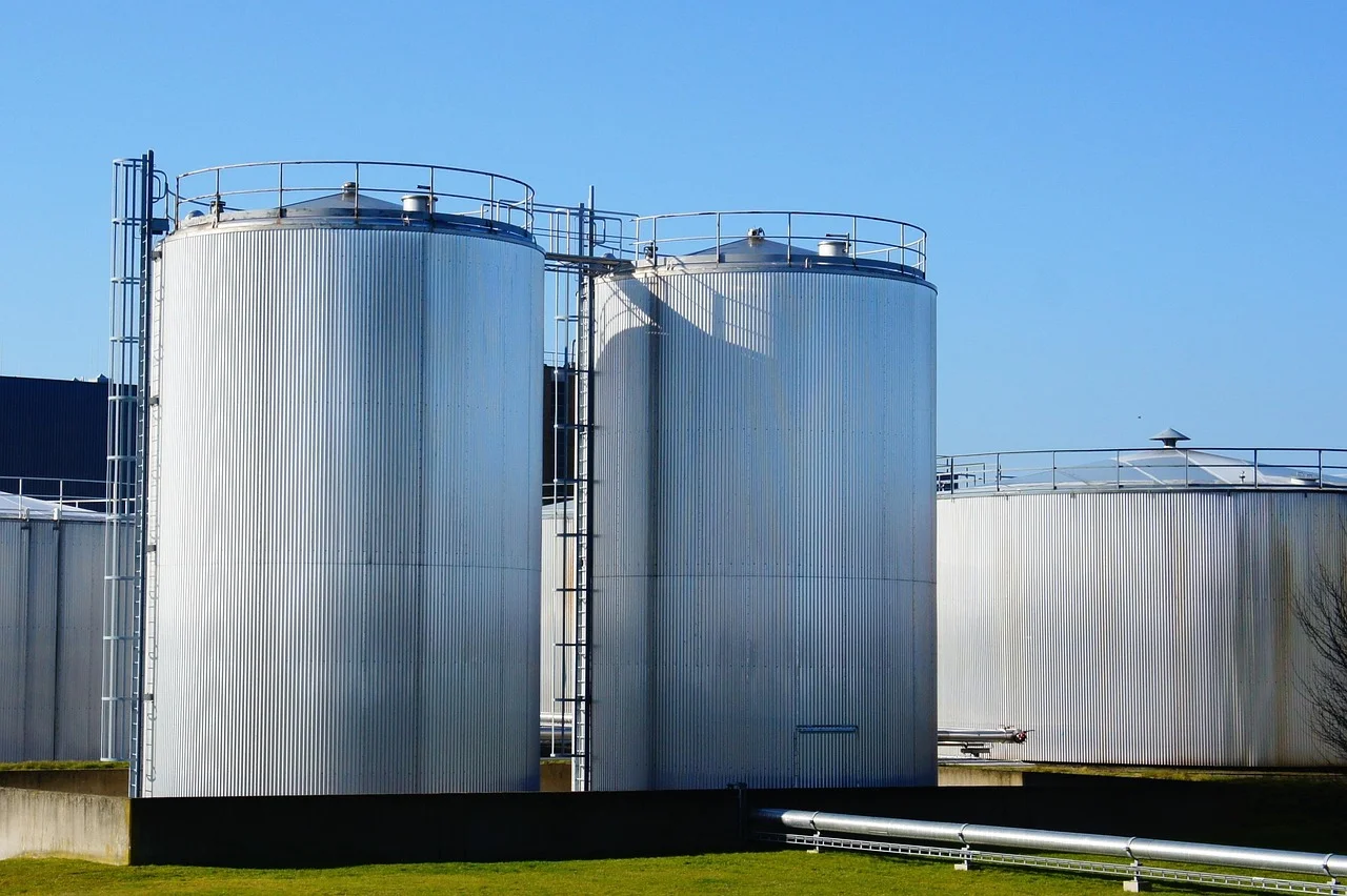 Tanques cilíndricos de almacenamiento bajo un cielo azul